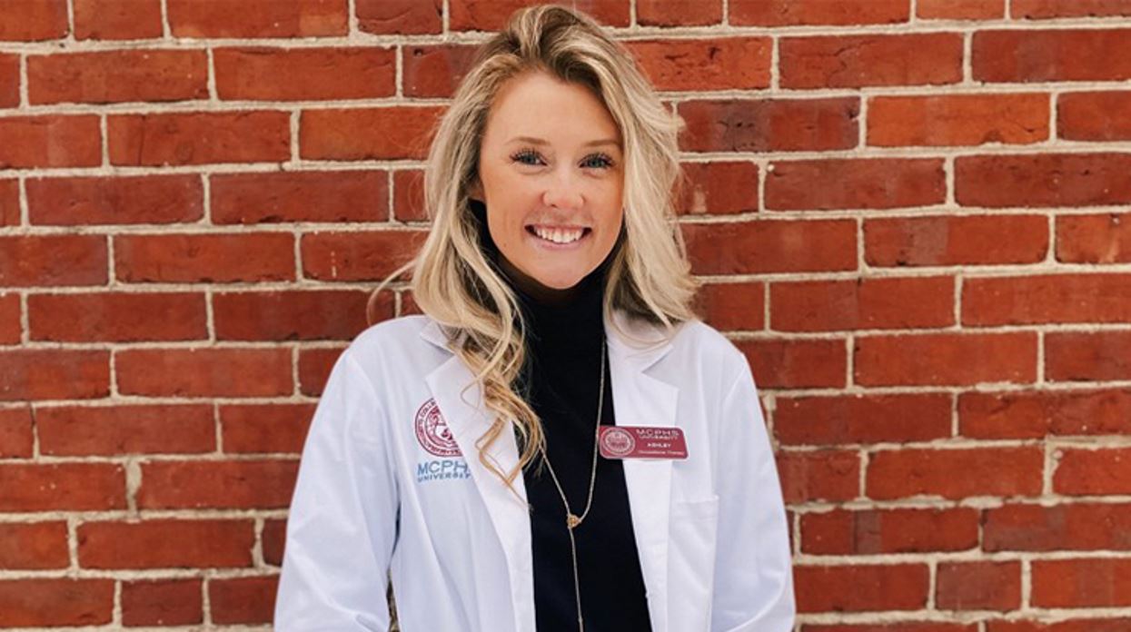 close up of Ashley Sullivan in a labcoat against a brick wall