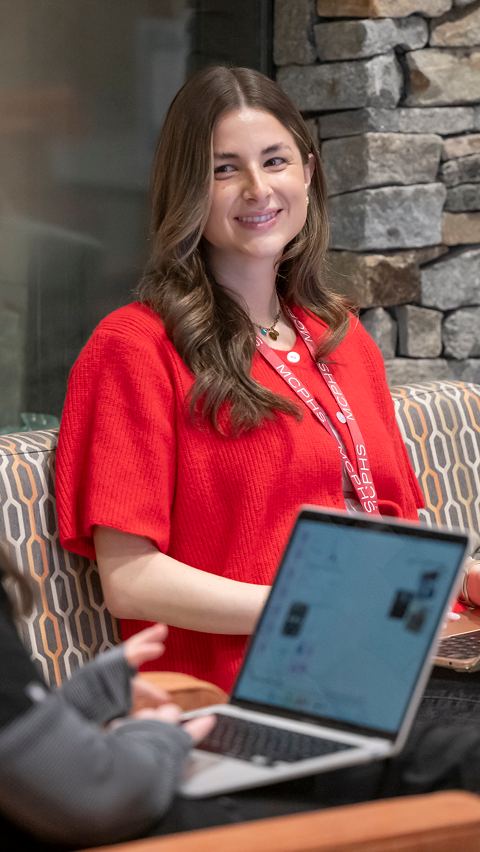 Smiling MCPHS student in red shirt wearing a lanyard. 