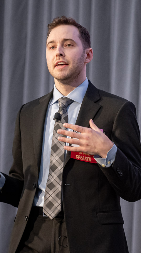 Male in a suit talking. 