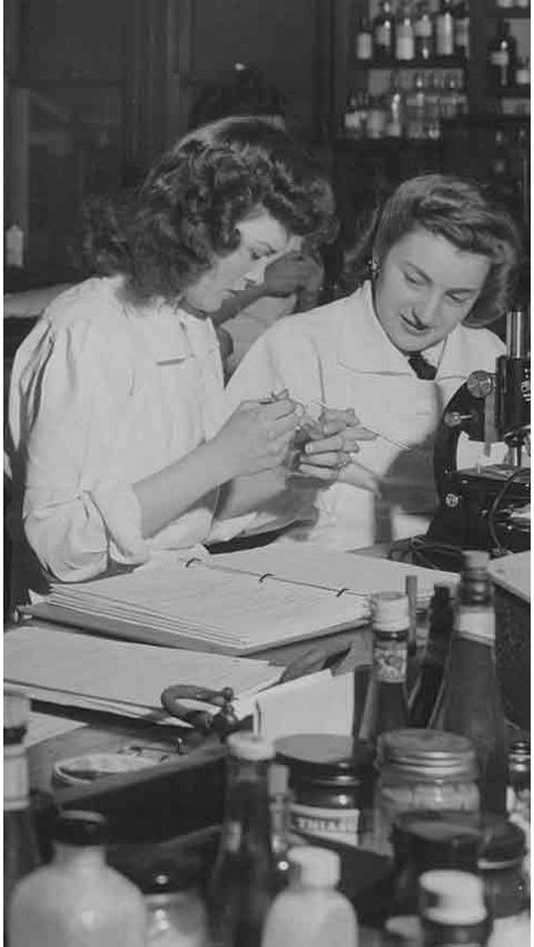 Black and white historical photo of female students in a chemistry lab. 