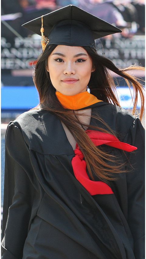 Female wearing graduation cap and gown. 