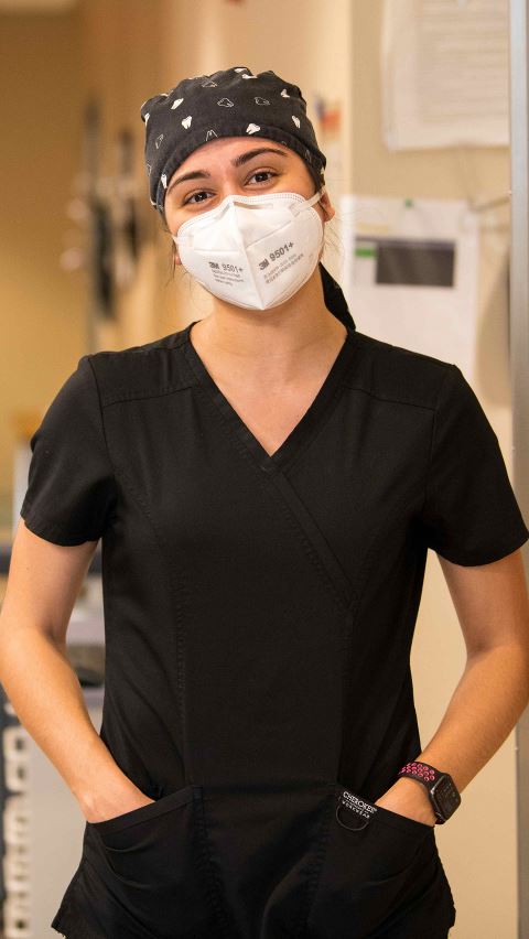 Female student in scrubs and a mask.