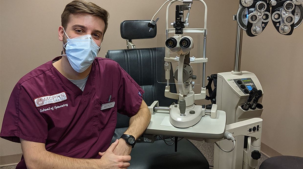 Close up of Jesse Alibrando with optometry equipment behind him