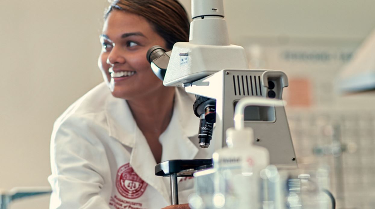 Female MCPHS student looks in microscope