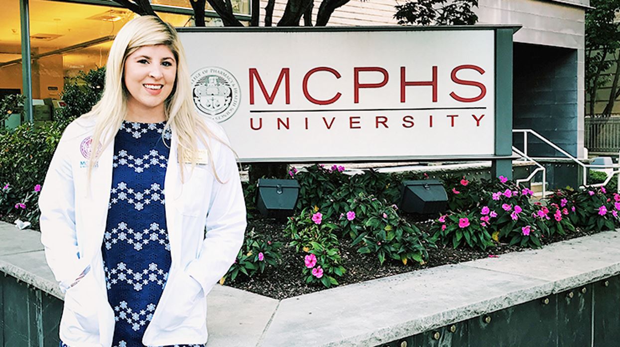 Nicole LaBrecque, CNMT, RT(N), NMTCB(CT),  Bachelor of Science in Nuclear Medicine Technology, in front of MCPHS sign