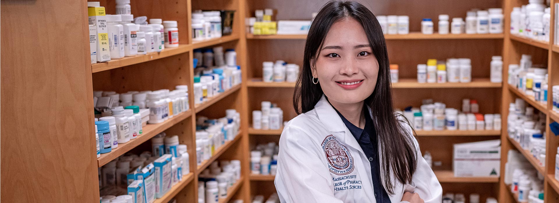 Smiling Pharmacy student in white coat.