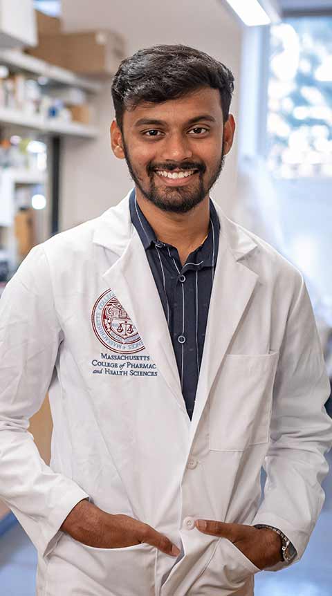 Male student wearing a white coat. 