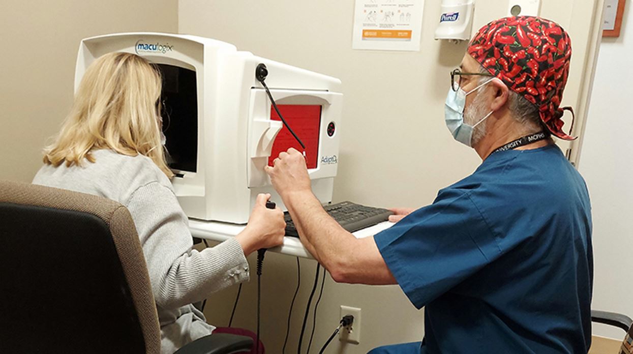 MCPHS Optometry Professor Dr. Larry Baitch using the Dark Adaptometry device loaned by Maculogix, Inc. with a patient to detect rate eye toxicity