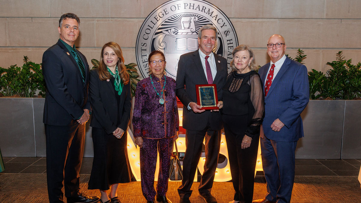 MCPHS NESA Leadership stand in front of the MCPHS seal.